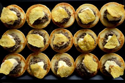 Plateau de pâtisseries garnies de crème blanche, nappées de chocolat et parsemées d'amandes effilées grillées.