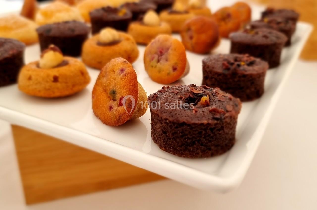 Assortiment de mini-gâteaux variés présentés sur un plateau blanc, incluant des options au chocolat et aux fruits.