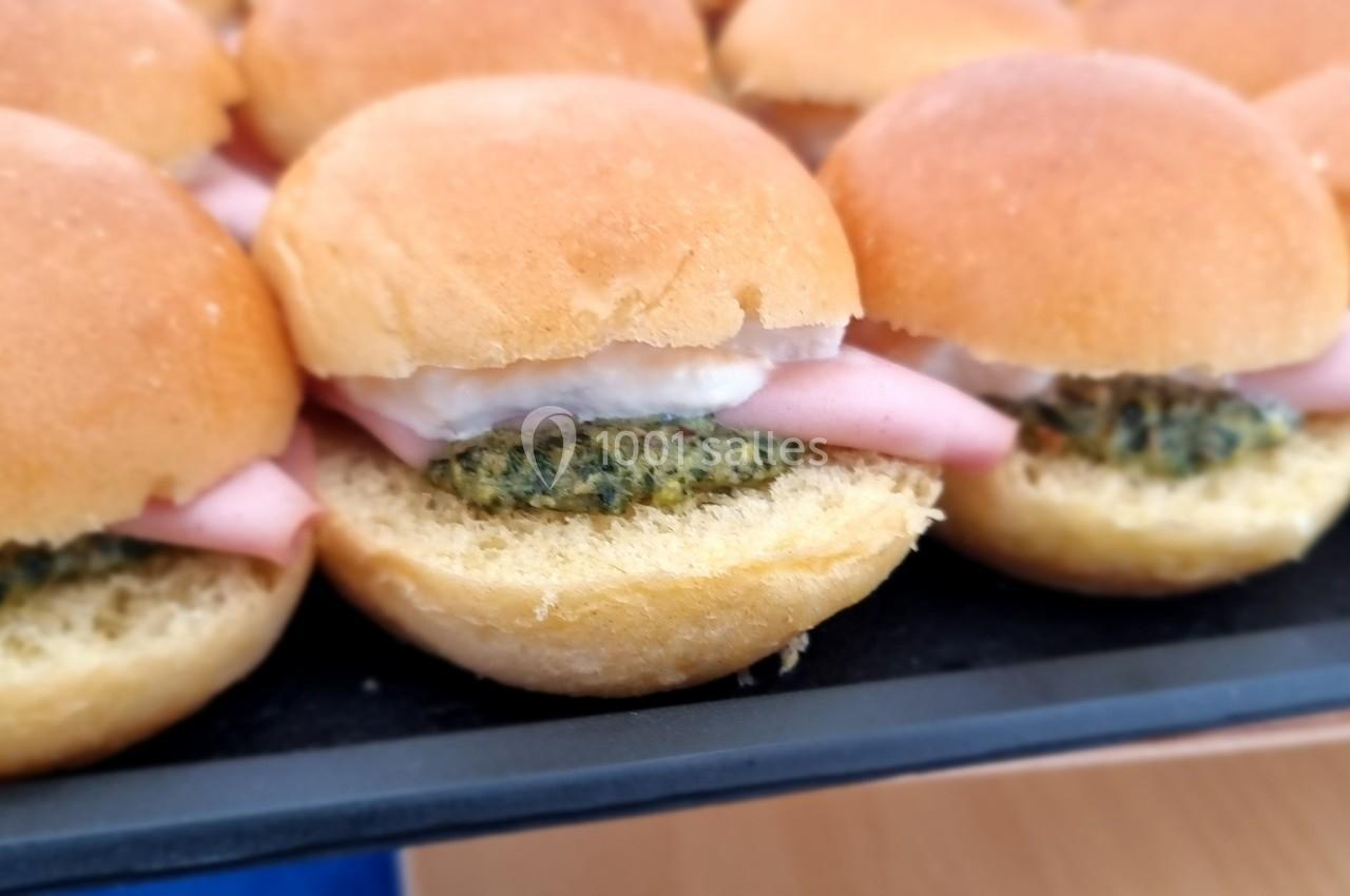 Plateau de mini-burgers garnis de viande, sauce blanche et galettes végétales, servis sur du pain brioché.