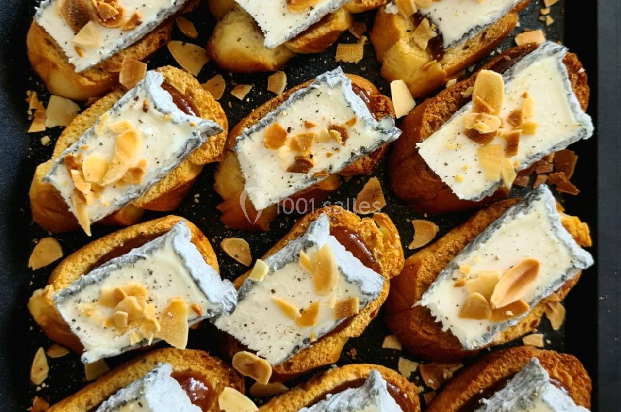 Plateau de petits choux garnis de crème et décorés d'amandes effilées grillées.