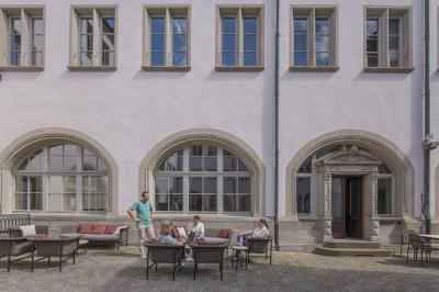 Miniature Location salle Strasbourg (Bas-Rhin) - Now Coworking Strasbourg #6 Salle lumineuse avec tables hautes, chaises, grande porte vitrée, fenêtres cintrées et coin kitchenette équipé.