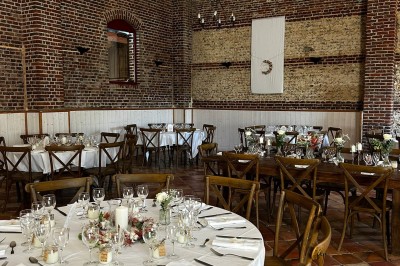 Miniature Location salle Haudricourt (Seine-Maritime) - La Mare du Bois #30 Salle de réception en briques avec éclairage chaleureux, grande table décorée de fleurs et vaisselle élégante.