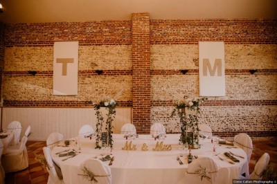 Miniature Location salle Haudricourt (Seine-Maritime) - La Mare du Bois #11 Salle de réception en briques avec éclairage chaleureux, grande table décorée de fleurs et vaisselle élégante.