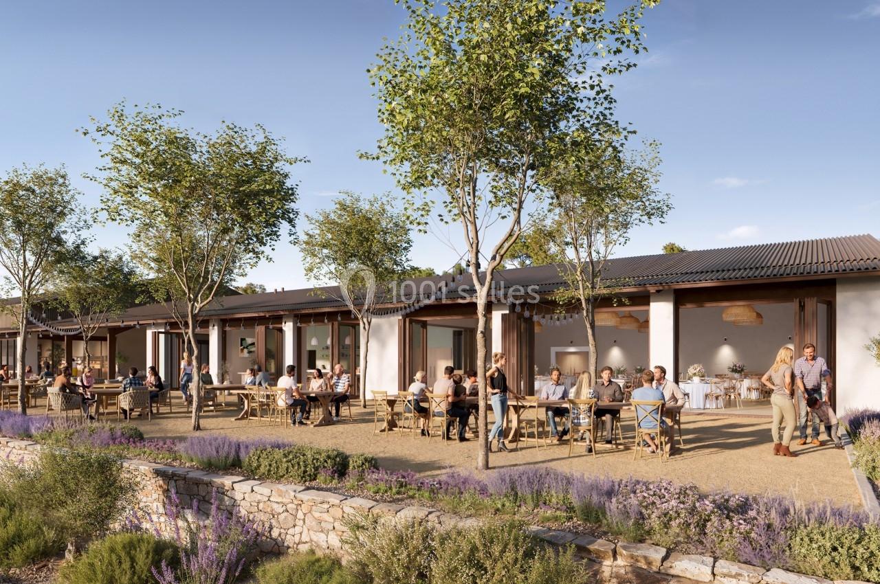 Terrasse d'un restaurant entourée de lavande et d'arbres, avec des clients assis à des tables en extérieur.
