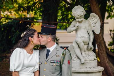 Un couple en tenue de mariage pose dans une forêt verdoyante, éclairée par une lumière douce.
