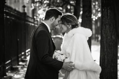 Un couple en tenue de mariage pose dans une forêt verdoyante, éclairée par une lumière douce.