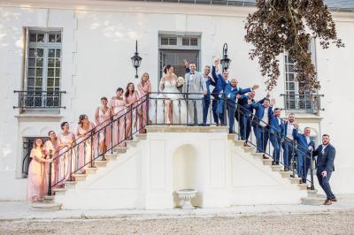 Un couple en tenue de mariage pose dans une forêt verdoyante, éclairée par une lumière douce.