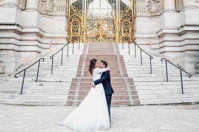 Un couple en tenue de mariage pose dans une forêt verdoyante, éclairée par une lumière douce.