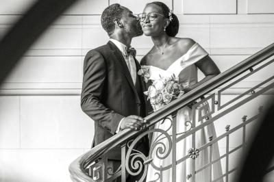 Un couple en tenue de mariage pose dans une forêt verdoyante, éclairée par une lumière douce.