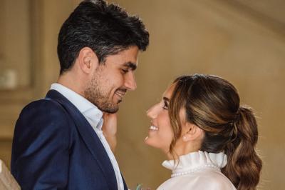 Un couple en tenue de mariage pose dans une forêt verdoyante, éclairée par une lumière douce.