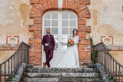 Un couple en tenue de mariage pose dans une forêt verdoyante, éclairée par une lumière douce.