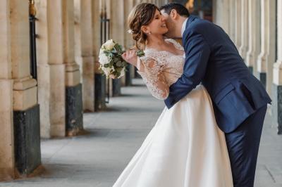 Un couple en tenue de mariage pose dans une forêt verdoyante, éclairée par une lumière douce.