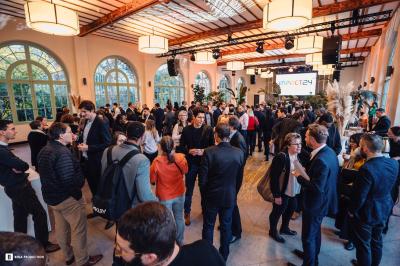 Des personnes assistent à une présentation dans une salle moderne avec un écran affichant un ordre du jour.