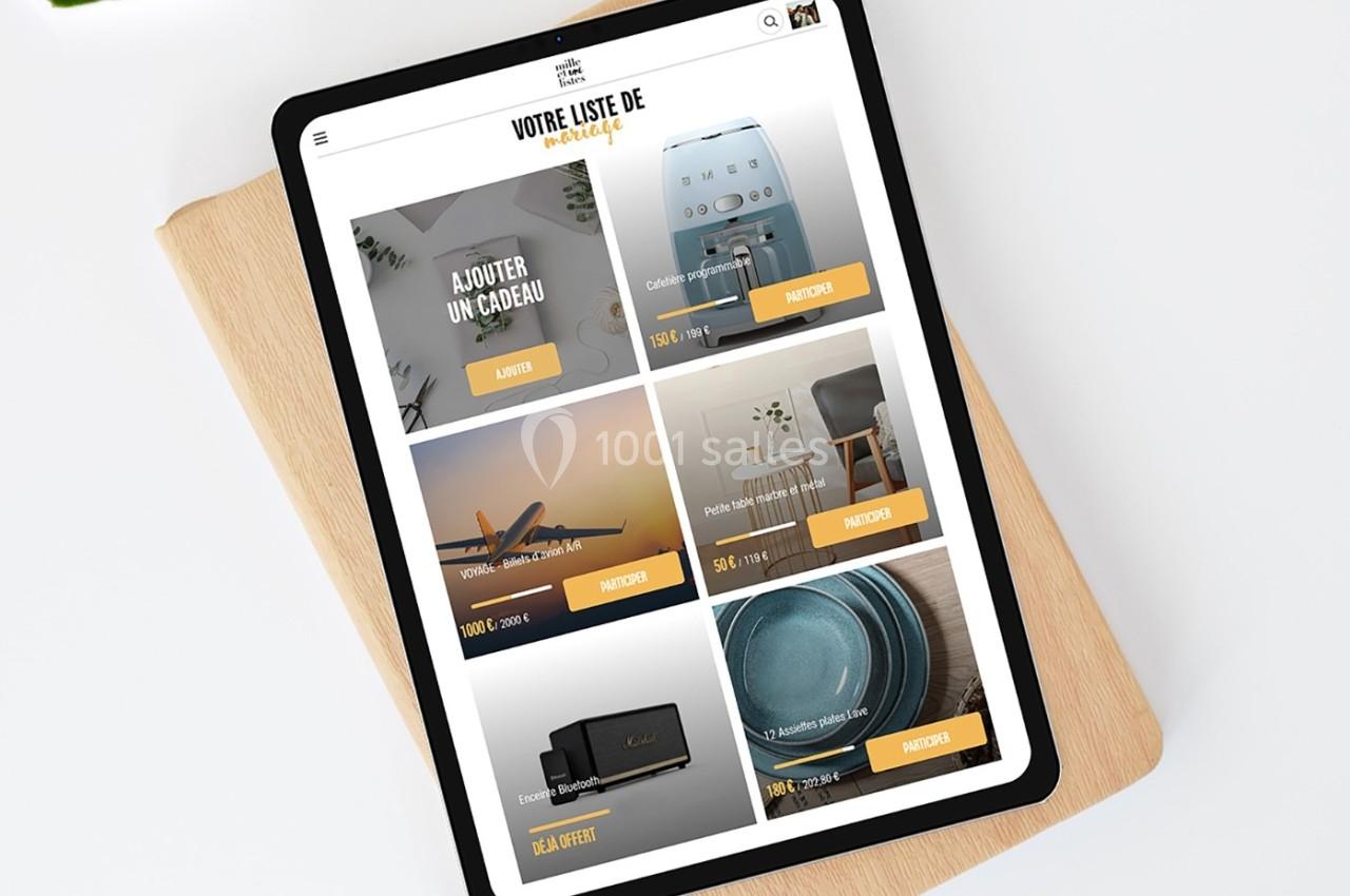 Tablette affichant une liste de produits variés avec images, descriptions et boutons d'action sur une table en bois clair.