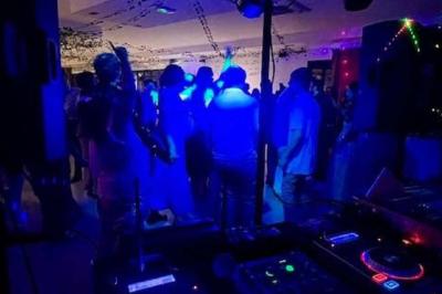 Salle de réception décorée avec des tables dressées et un plan rapproché d'une console de mixage audio.