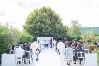 Façade d'un bâtiment moderne éclairé de nuit, avec des plantes et un panneau ’La Scène’ visible.