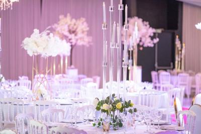 Façade d'un bâtiment moderne éclairé de nuit, avec des plantes et un panneau ’La Scène’ visible.