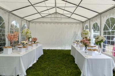 Façade d'un bâtiment moderne éclairé de nuit, avec des plantes et un panneau ’La Scène’ visible.