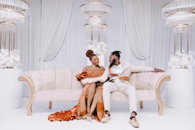 Façade d'un bâtiment moderne éclairé de nuit, avec des plantes et un panneau ’La Scène’ visible.