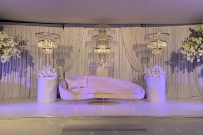 Façade d'un bâtiment moderne éclairé de nuit, avec des plantes et un panneau ’La Scène’ visible.