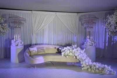 Façade d'un bâtiment moderne éclairé de nuit, avec des plantes et un panneau ’La Scène’ visible.