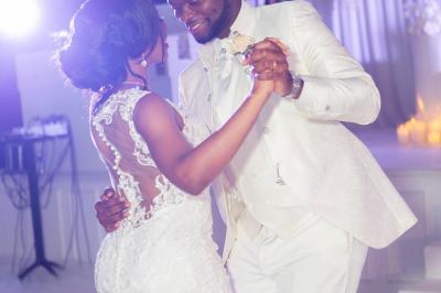Façade d'un bâtiment moderne éclairé de nuit, avec des plantes et un panneau ’La Scène’ visible.