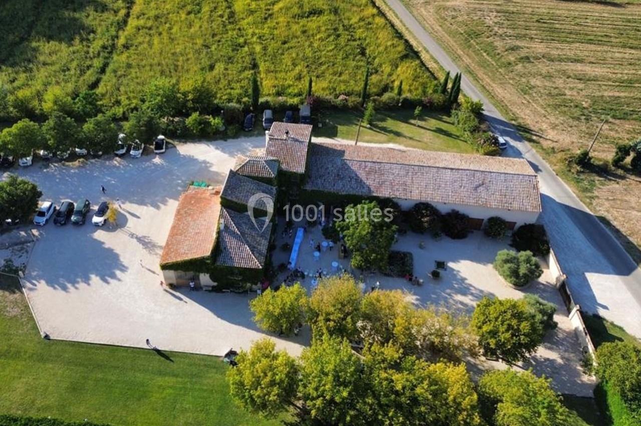 Vue aérienne d'un domaine rural avec bâtiments en pierre, cour arborée et champs environnants.