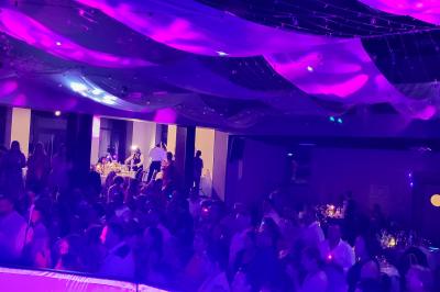 Miniature DJ Mâcon (Saône-et-Loire) - Mjps Sonorisation #2 Poste de DJ avec ordinateur portable affichant un logiciel de mixage, platine et microphone sur une table éclairée en violet.