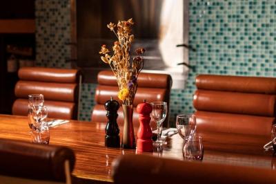 Miniature Location salle Rueil-Malmaison (Hauts-de-Seine) - La Casa #9 Salle de restaurant avec des tables dressées, des chaises en cuir marron et une enseigne murale ’LA CASA’.