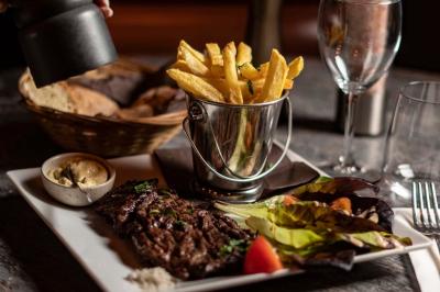 Miniature Location salle Rueil-Malmaison (Hauts-de-Seine) - La Casa #13 Salle de restaurant avec des tables dressées, des chaises en cuir marron et une enseigne murale ’LA CASA’.