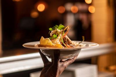 Miniature Location salle Rueil-Malmaison (Hauts-de-Seine) - La Casa #18 Salle de restaurant avec des tables dressées, des chaises en cuir marron et une enseigne murale ’LA CASA’.