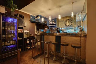 Miniature Location salle Rueil-Malmaison (Hauts-de-Seine) - La Casa #8 Salle de restaurant avec des tables dressées, des chaises en cuir marron et une enseigne murale ’LA CASA’.