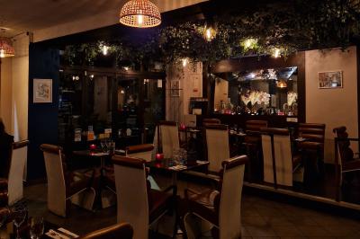 Miniature Location salle Rueil-Malmaison (Hauts-de-Seine) - La Casa #2 Salle de restaurant avec des tables dressées, des chaises en cuir marron et une enseigne murale ’LA CASA’.