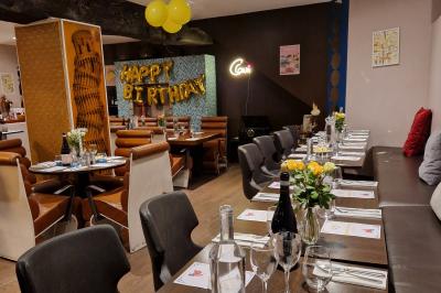 Miniature Location salle Rueil-Malmaison (Hauts-de-Seine) - La Casa #5 Salle de restaurant avec des tables dressées, des chaises en cuir marron et une enseigne murale ’LA CASA’.