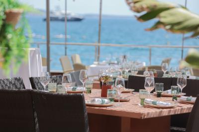 Miniature Location salle Mandelieu-la-Napoule (Alpes-Maritimes) - Restaurant le Repere #8 Rangées de chaises blanches alignées en extérieur, probablement pour un événement ou une cérémonie.