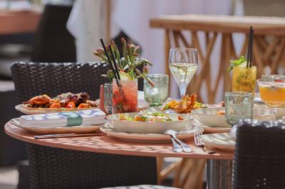 Miniature Location salle Mandelieu-la-Napoule (Alpes-Maritimes) - Restaurant le Repere #9 Rangées de chaises blanches alignées en extérieur, probablement pour un événement ou une cérémonie.
