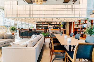 Miniature Location salle Lyon 2 (Rhône) - Lumen #3 Un café moderne avec un comptoir en bois, des tabourets, des clients et des baristas en pleine discussion.