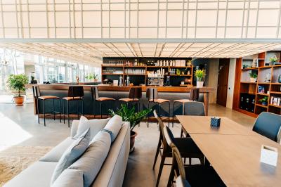 Miniature Location salle Lyon 2 (Rhône) - Lumen #2 Un café moderne avec un comptoir en bois, des tabourets, des clients et des baristas en pleine discussion.