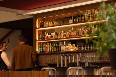 Miniature Location salle Villeneuve-d'Ascq (Nord) - Bistrot Rita #5 Des personnes assises à des tables dans un restaurant lumineux, discutant et partageant un repas près de grandes fenêtres.