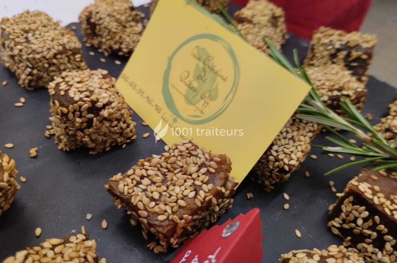 Carrés de pâte de fruits enrobés de graines de sésame, présentés sur un plateau avec une carte de visite.