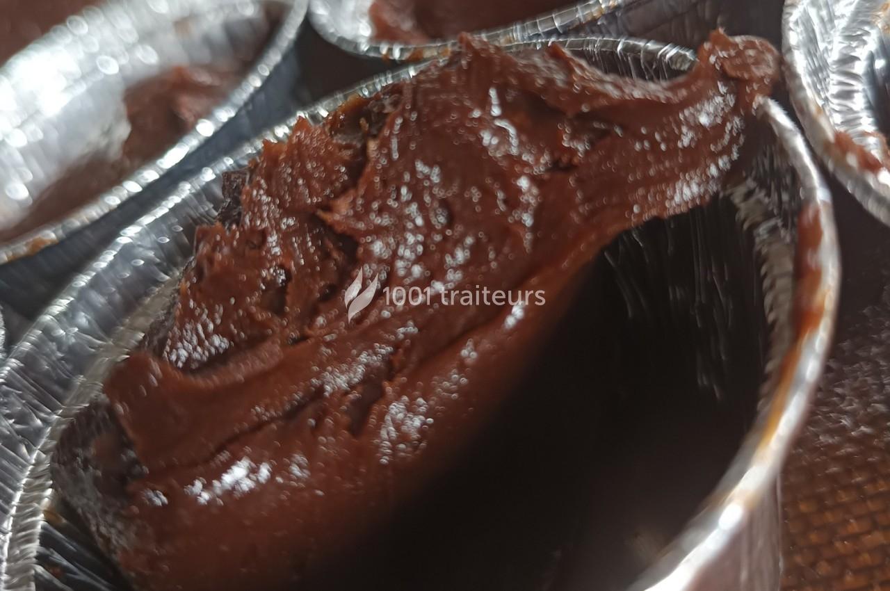 Pâte au chocolat épaisse dans un moule en aluminium, prête pour une préparation culinaire.