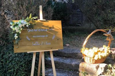 Salle de réception avec tables rondes dressées, nappes blanches, chemins de table en dentelle et décoration élégante.