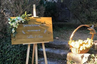 Salle de réception décorée avec des tables rondes dressées, nappes blanches et chaises ornées de nœuds beige.