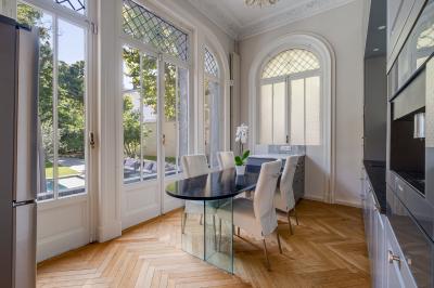 Miniature Location salle Lyon 3 (Rhône) - Hôtel Particulier Napoléon #10 Chambre lumineuse avec lit double, bureau, poutres apparentes et murs verts, décorée avec des tableaux.