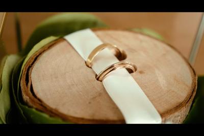 Chaussures blanches à talons posées sur un sol en bois, près d'une robe en tissu léger.