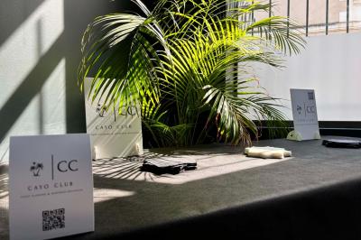 Logo circulaire du Cayo Club avec des palmiers, un soleil et le texte ’Event Planning & Happiness Organizer’.