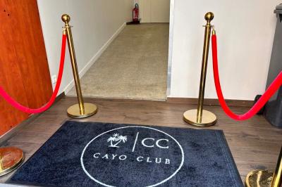 Logo circulaire du Cayo Club avec des palmiers, un soleil et le texte ’Event Planning & Happiness Organizer’.