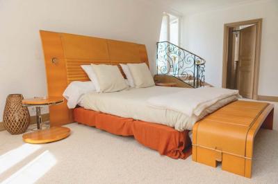 Salle de bain luxueuse avec baignoire en marbre, double vasque, miroirs, et fenêtre donnant sur un jardin.