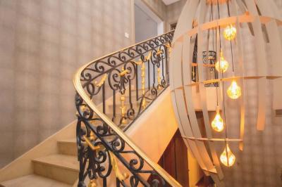 Salle de bain luxueuse avec baignoire en marbre, double vasque, miroirs, et fenêtre donnant sur un jardin.