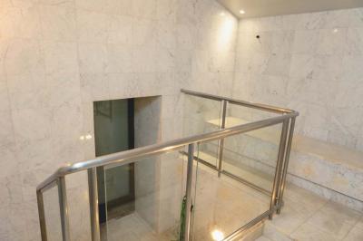 Salle de bain luxueuse avec baignoire en marbre, double vasque, miroirs, et fenêtre donnant sur un jardin.